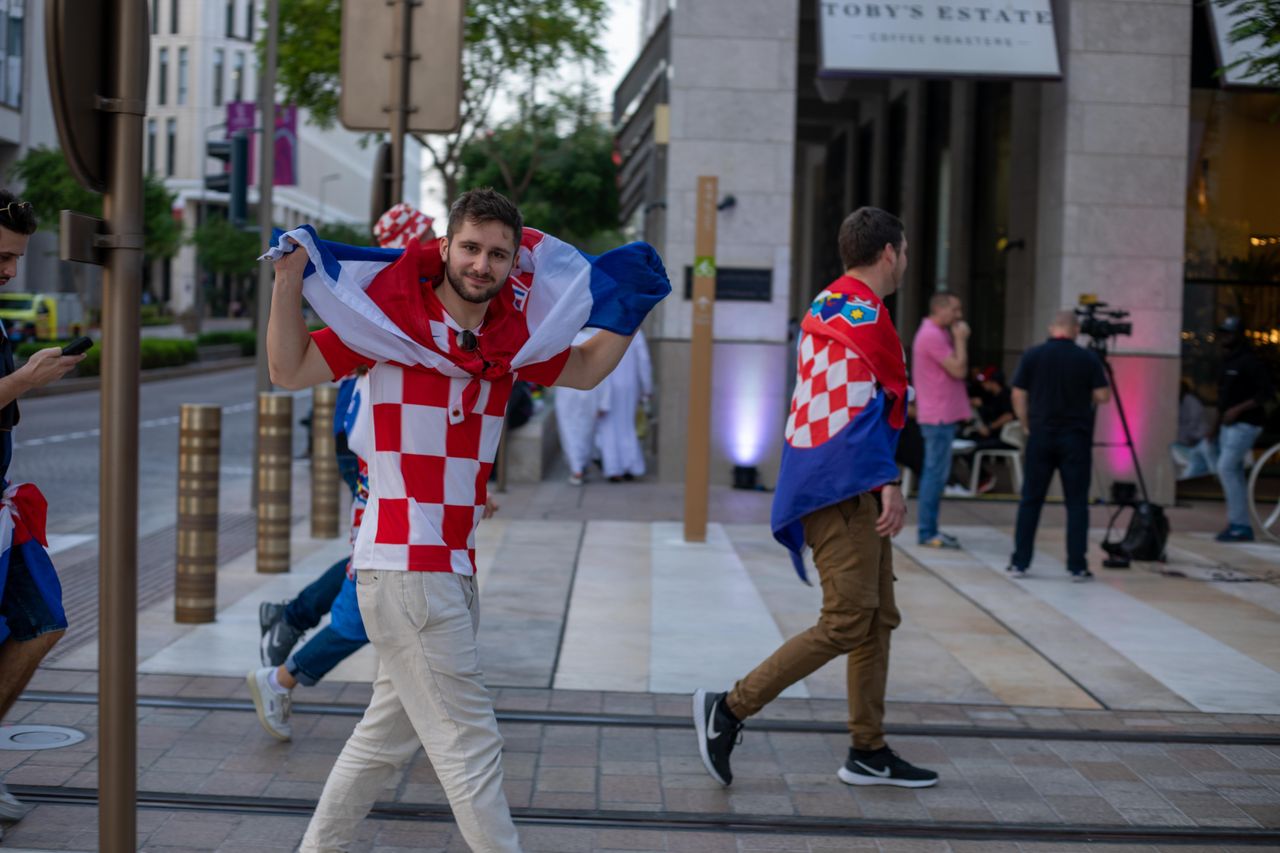 gallery-4 Croatian soccer fans celebrating with flags in the streets of Doha, Qatar during the World Cup.
