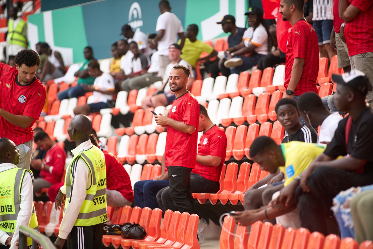gallery-5 Diverse group of soccer fans wearing red jerseys at a lively stadium event.