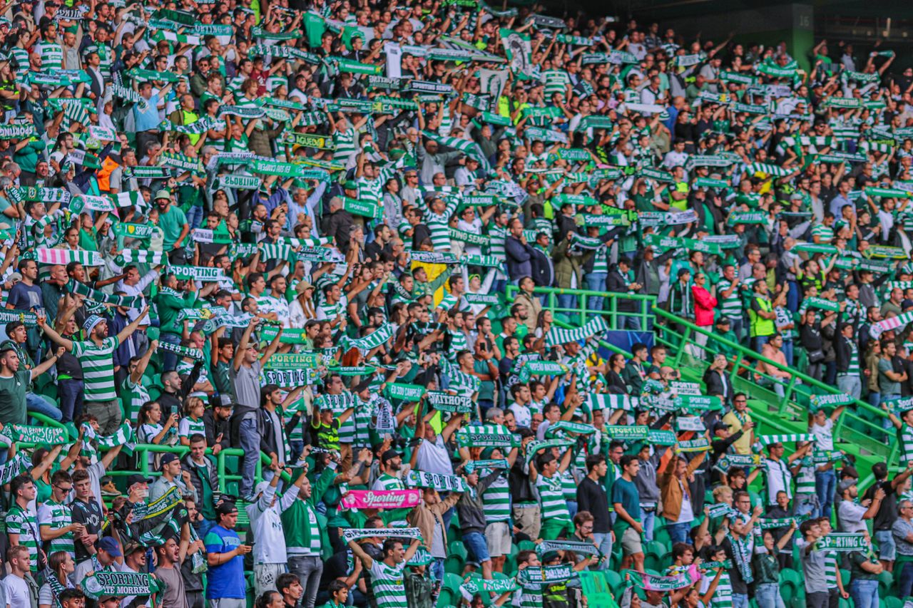 services-02 Energetic crowd of soccer fans cheering with scarves at a stadium in Lisbon, Portugal.