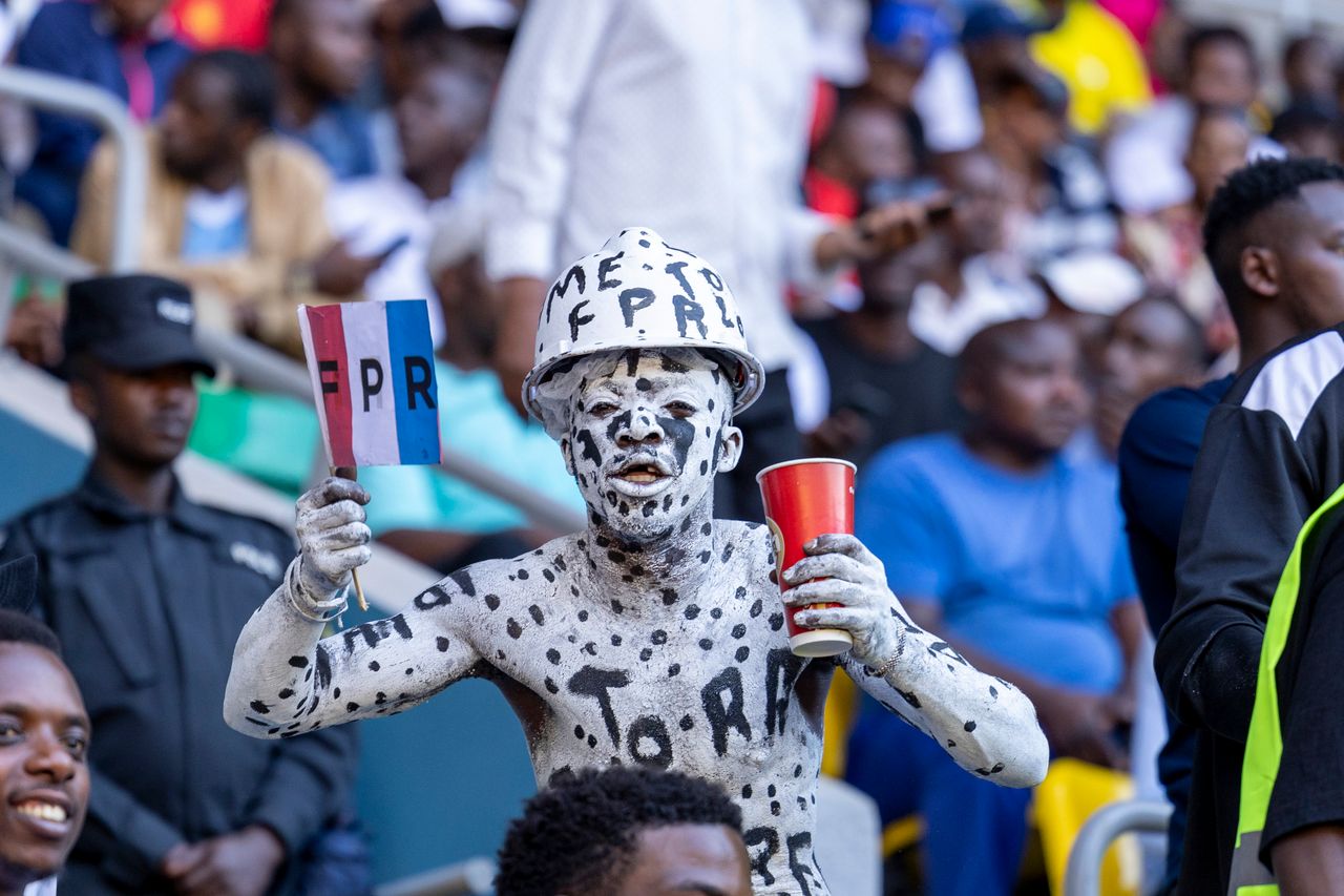 gallery-3 Enthusiastic sports fan with body paint holding a flag at a lively stadium.
