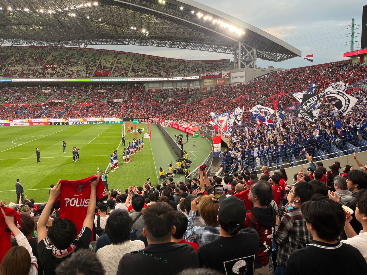 about-01 A thrilling soccer match at a packed stadium with energetic fans waving flags and cheering in Japan.