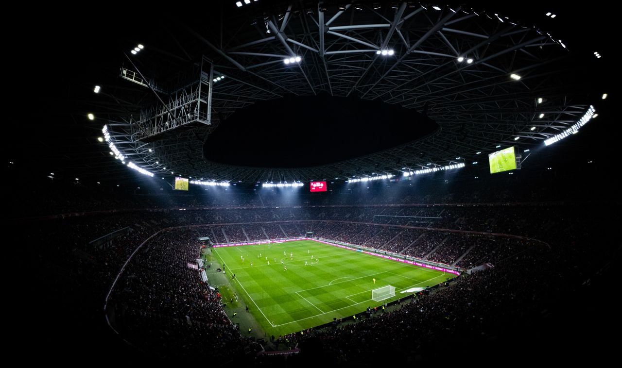 services-01 Aerial view of a night football match in Budapest. Illuminated stadium full of fans adds dramatic atmosphere.