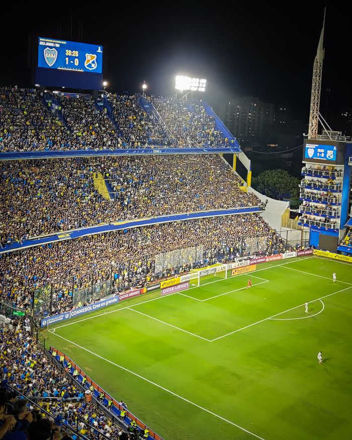 why-choose-us Vibrant soccer game at La Bombonera Stadium in Buenos Aires. Enthusiastic fans fill the stands under bright lights.