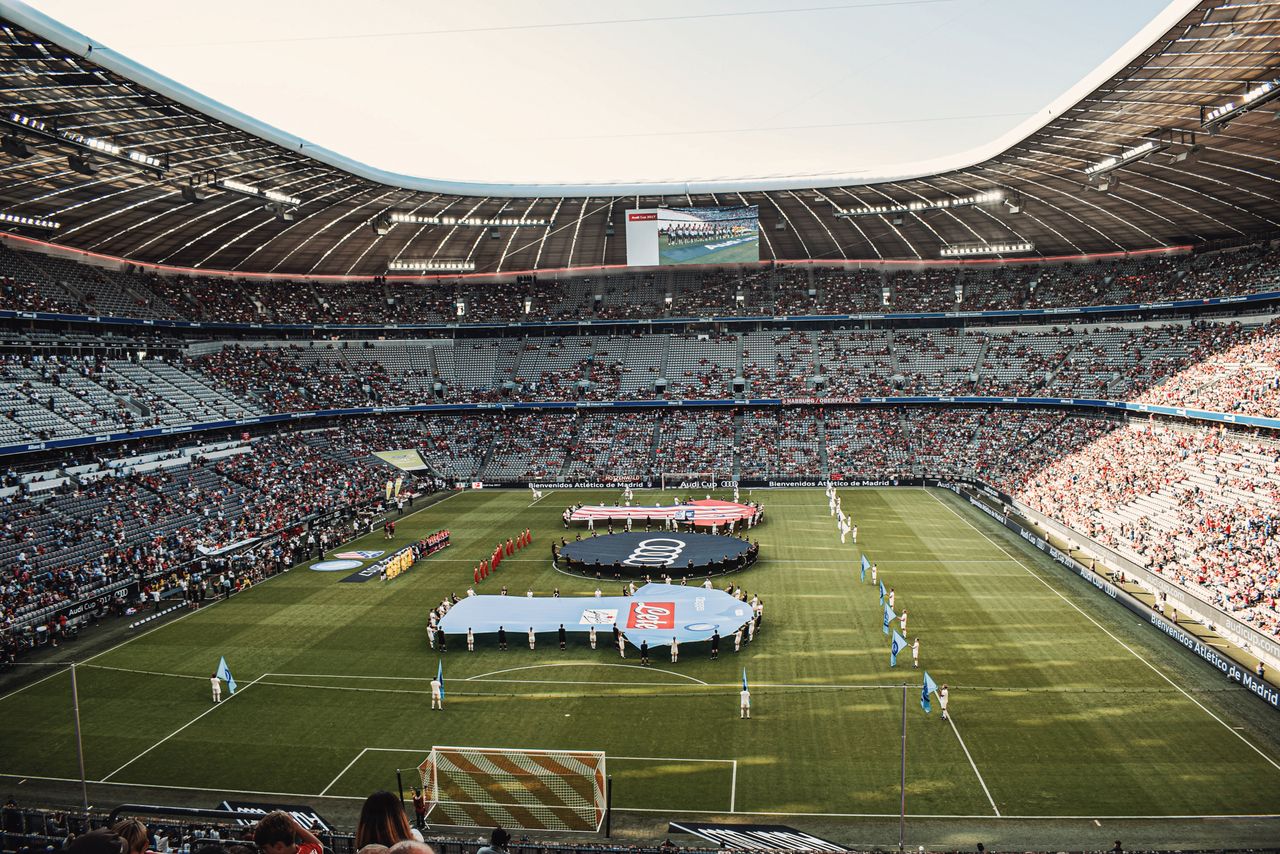 services-03 Captivating view of a soccer match at Munich's iconic Allianz Arena, filled with excited fans.